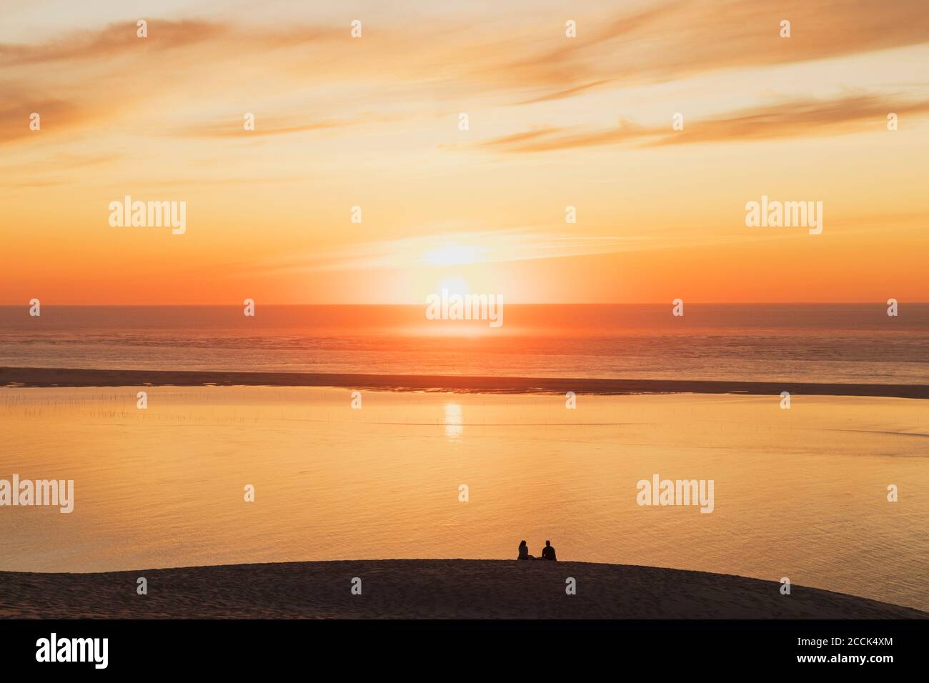 Silhouette coppia guardando il tramonto sull'oceano Atlantico, Duna di Pilat, Nouvelle-Aquitaine, Francia Foto Stock