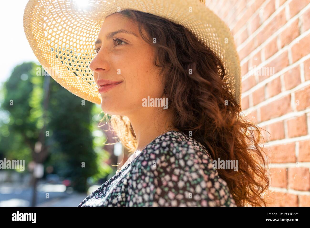 Primo piano di una giovane donna premurosa che indossa un cappello che guarda lontano Foto Stock