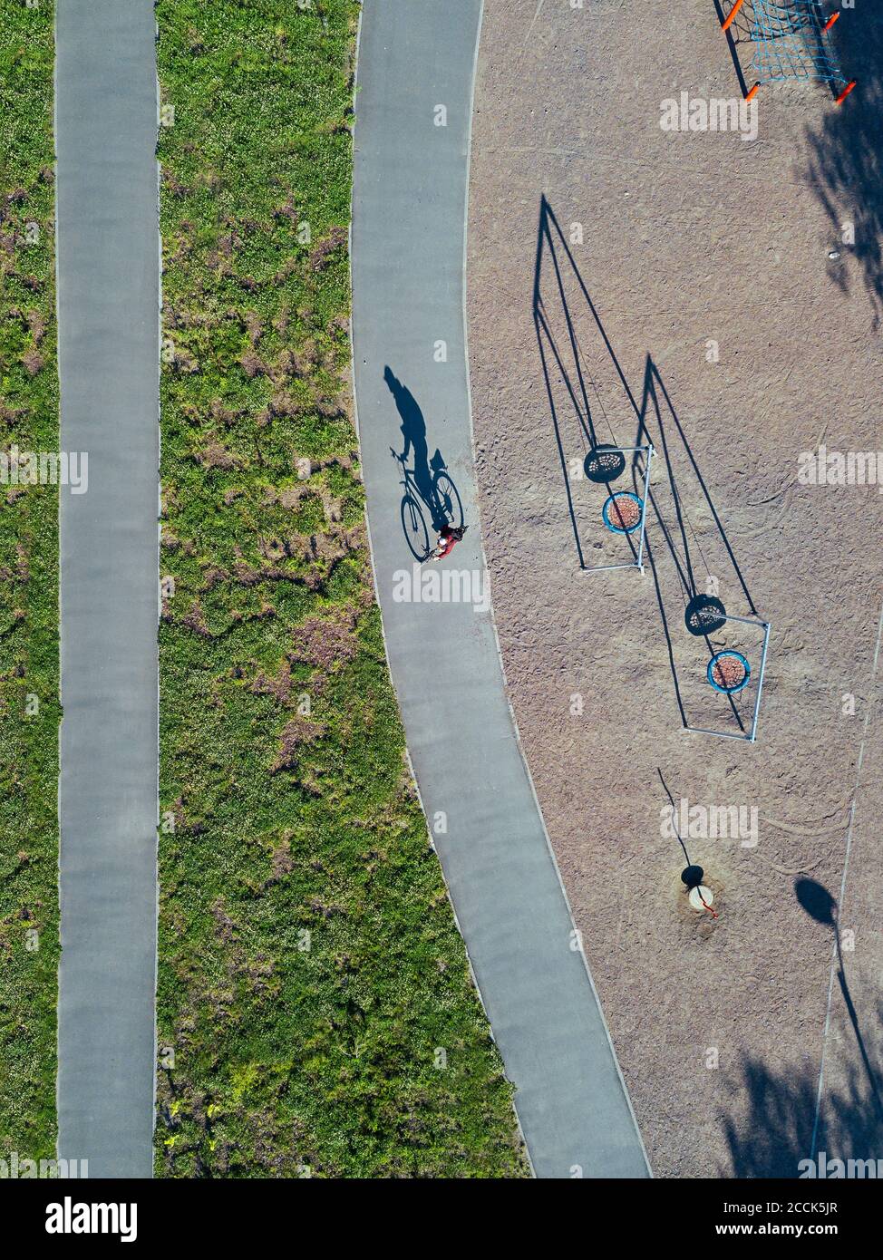 Russia, Tikhvin, uomo in bicicletta sul sentiero vicino parco giochi, vista aerea Foto Stock
