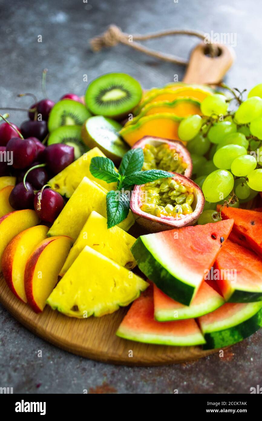Insalata di frutta con cocomero, kiwi, frutto della passione, uva, ciliegia, pesca e melone sulla taglierine Foto Stock