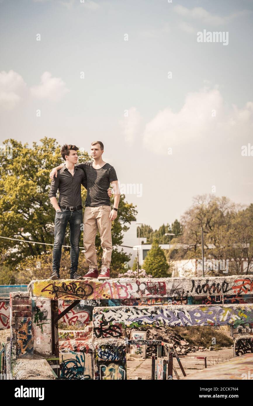 Due ragazzi adolescenti che si appendono in una vecchia corsa giù area industriale Foto Stock