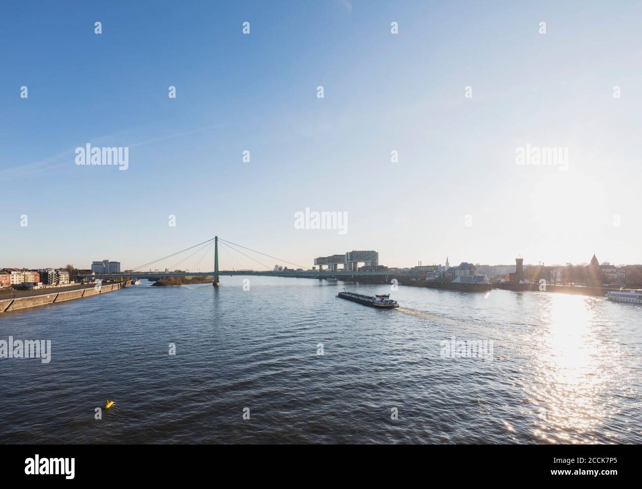 Germania, Renania Settentrionale-Vestfalia, Colonia, Sole che si erge sul Reno con il Rheinauhafen e il Ponte di Severin sullo sfondo Foto Stock