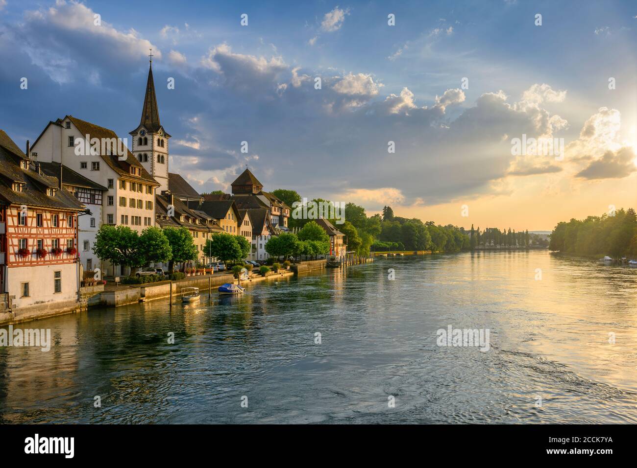 Svizzera, Cantone di Turgovia, Diessenhofen, Alto Reno e villaggio adiacente al tramonto nuvoloso Foto Stock