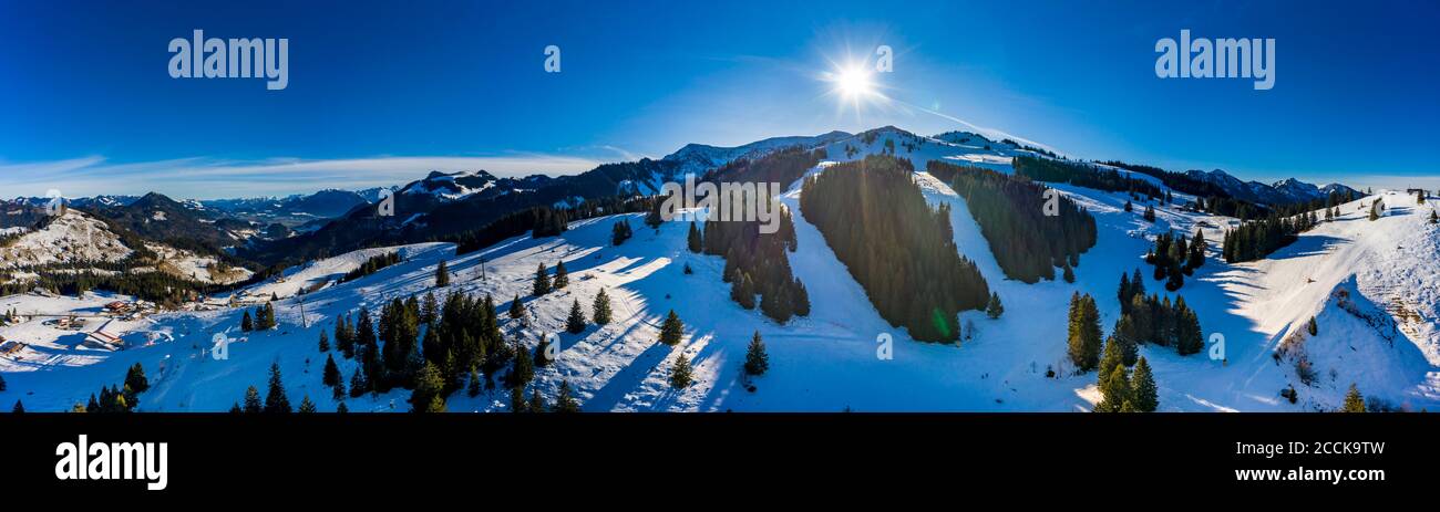 Panorama in elicottero del sole che splende sulle cime innevate di Mangfall Montagne Foto Stock