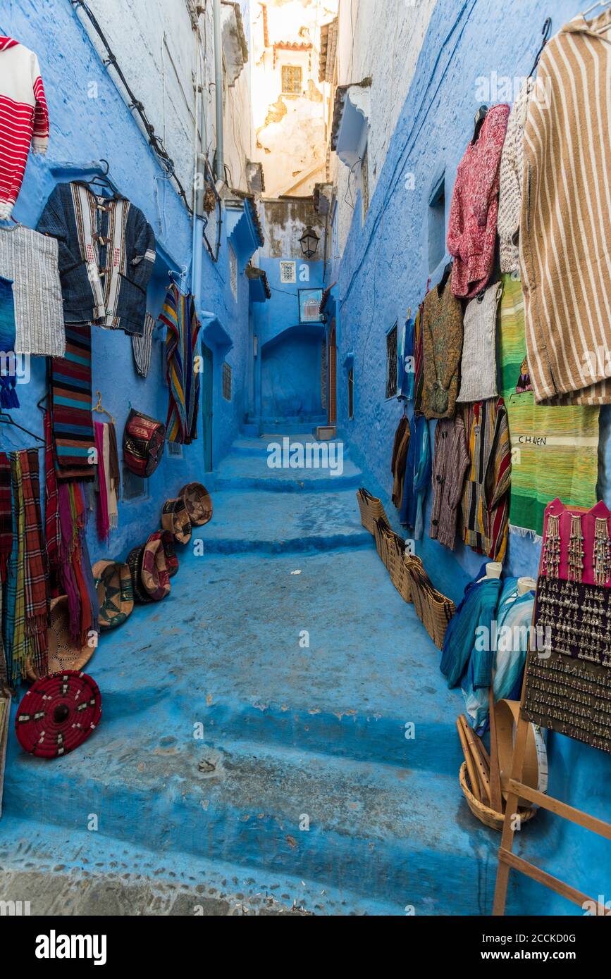 Prodotti artigianali disposti a parete e gradini in vendita nella città vecchia, Chefchaouen, Marocco Foto Stock