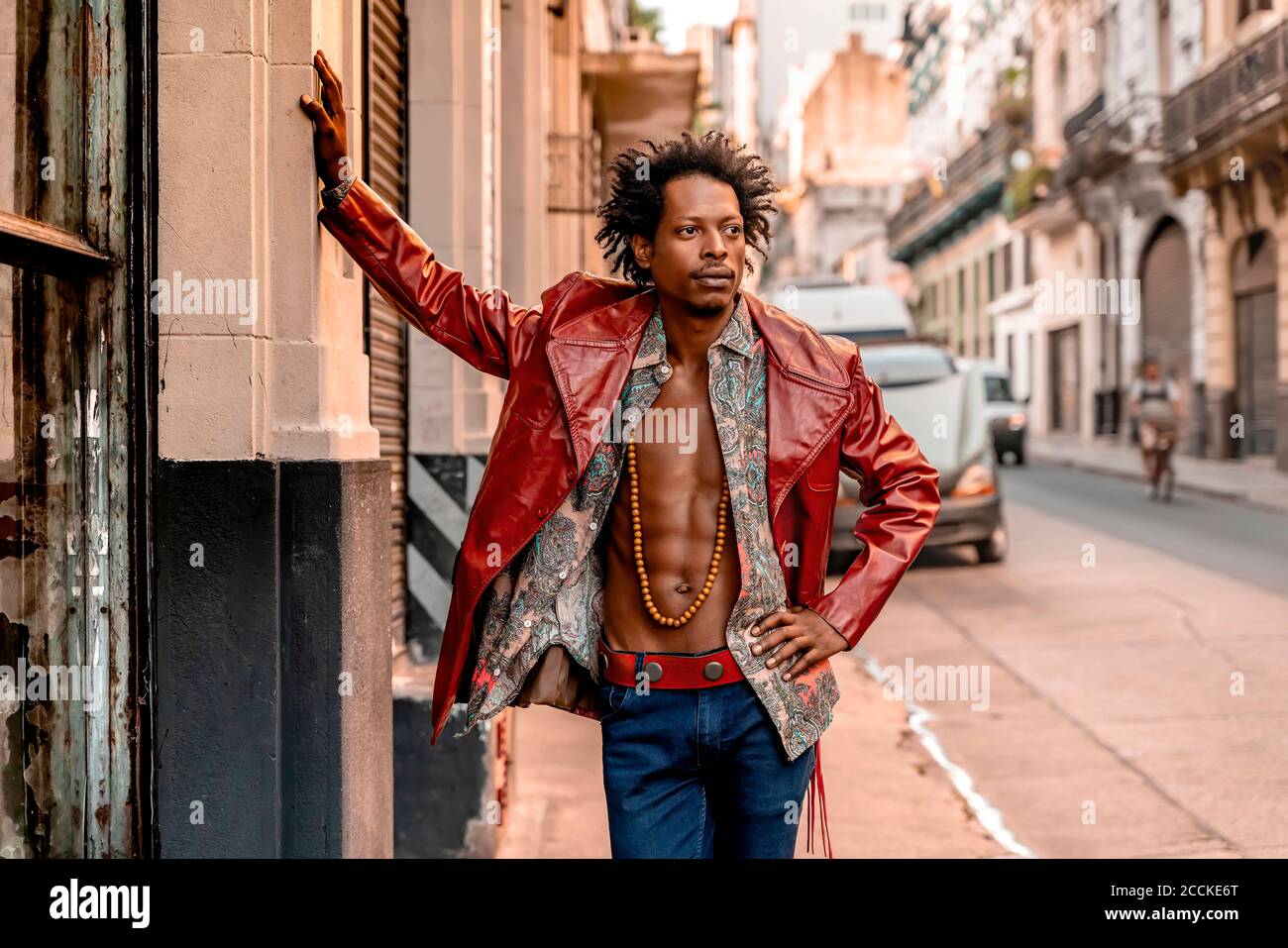 Uomo retrò che indossa una giacca in pelle mentre ti trovi sul marciapiede  durante il giorno di sole Foto stock - Alamy