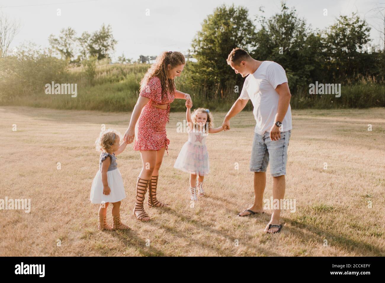 Genitori con due figlie in piedi su un prato Foto Stock