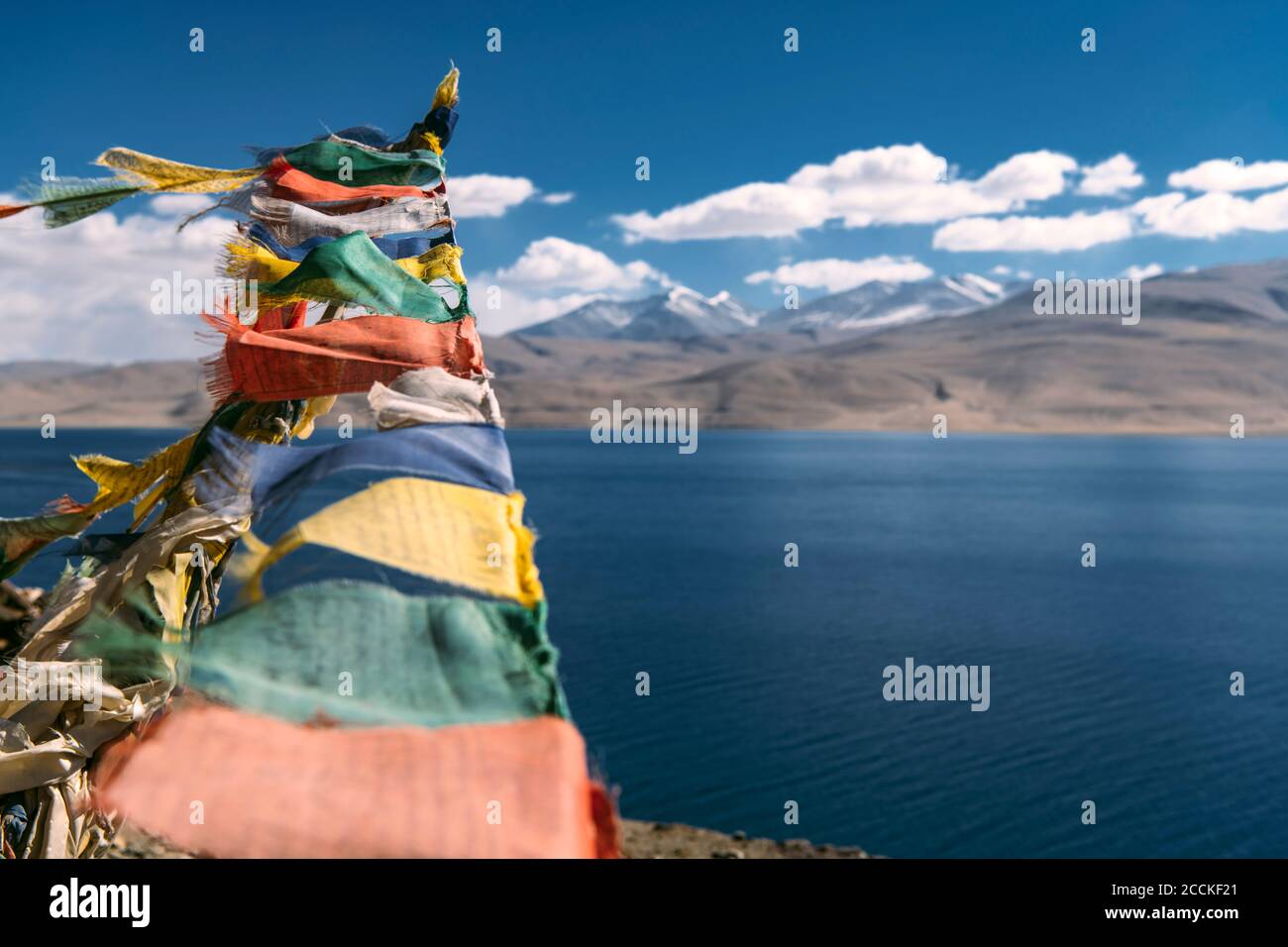 Colorate bandiere di preghiera appese contro il lago alpino Foto Stock
