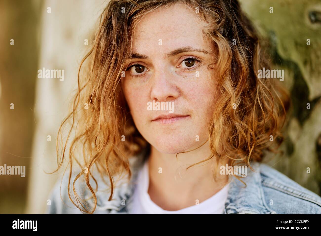 Primo piano di una donna mid adulta seria con capelli ondulati parcheggio Foto Stock