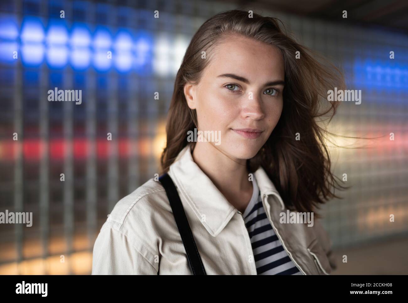 Primo piano di una bella donna contro un edificio illuminato in città Foto Stock