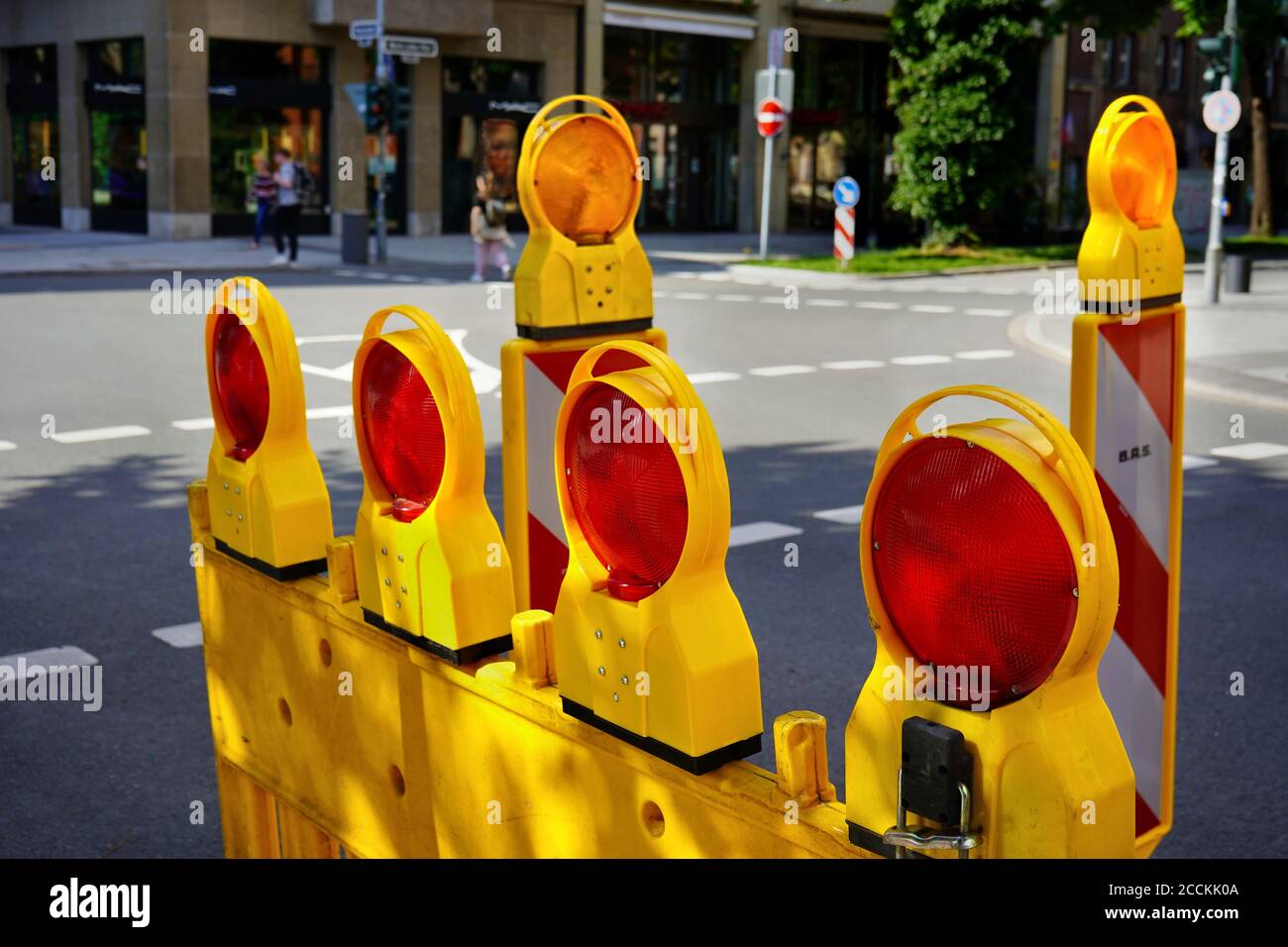 Blocco stradale giallo con luci rosse lampeggianti su una strada nel centro di Düsseldorf. Foto Stock