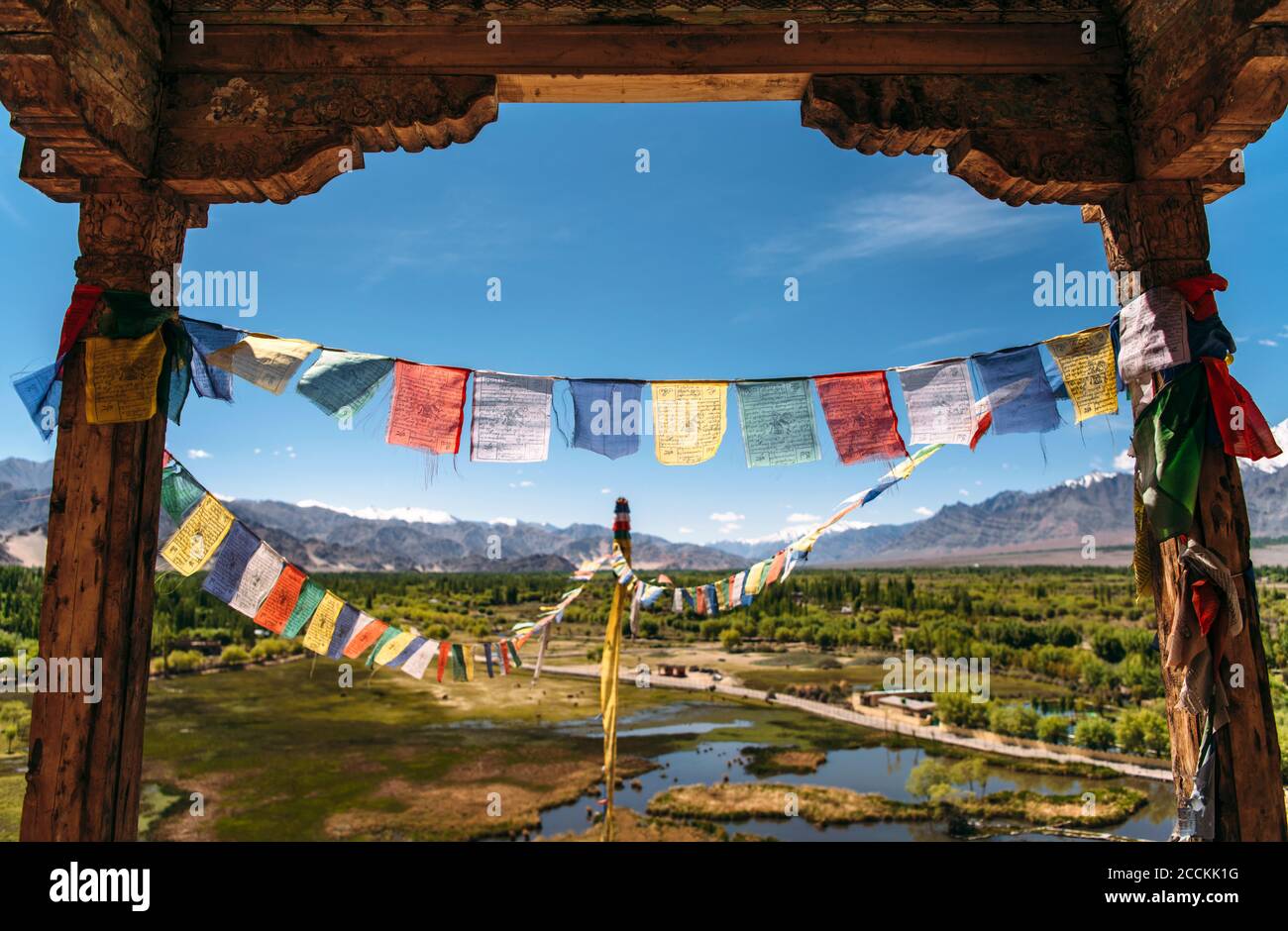 India, Ladakh, colorate bandiere di preghiera appese tra due vecchie colonne Foto Stock