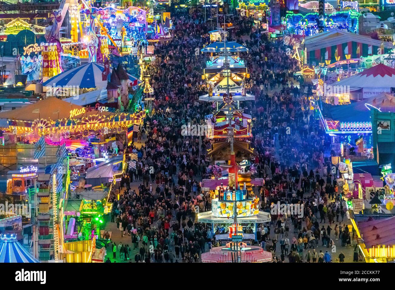Germania, Baviera, Monaco, drone vista di folle di persone che celebrano l'Oktoberfest nel vasto parco divertimenti al tramonto Foto Stock