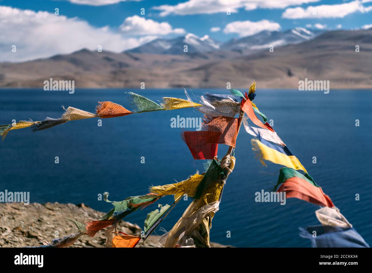 Colorate bandiere di preghiera appese contro il lago alpino Foto Stock