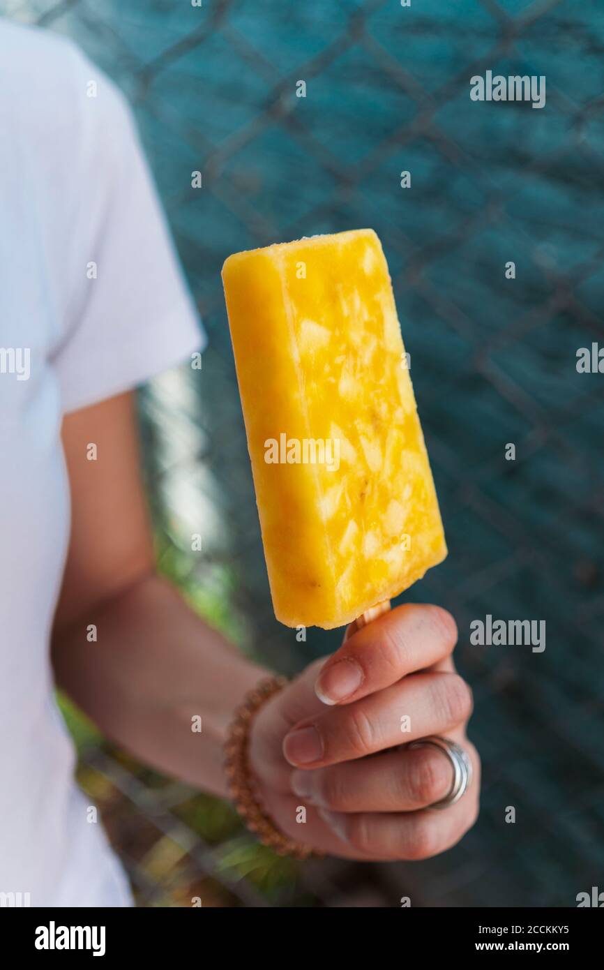 Primo piano di una donna che tiene il papsiclo giallo Foto Stock