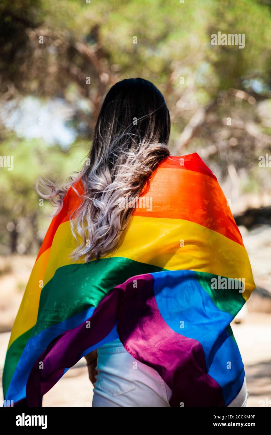 Vista posteriore della donna con bandiera dell'orgoglio Foto Stock