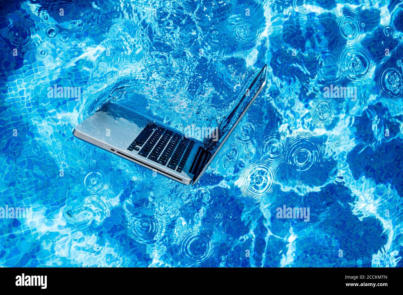 Vista ad alto angolo del computer portatile che galleggia sulla piscina Foto Stock