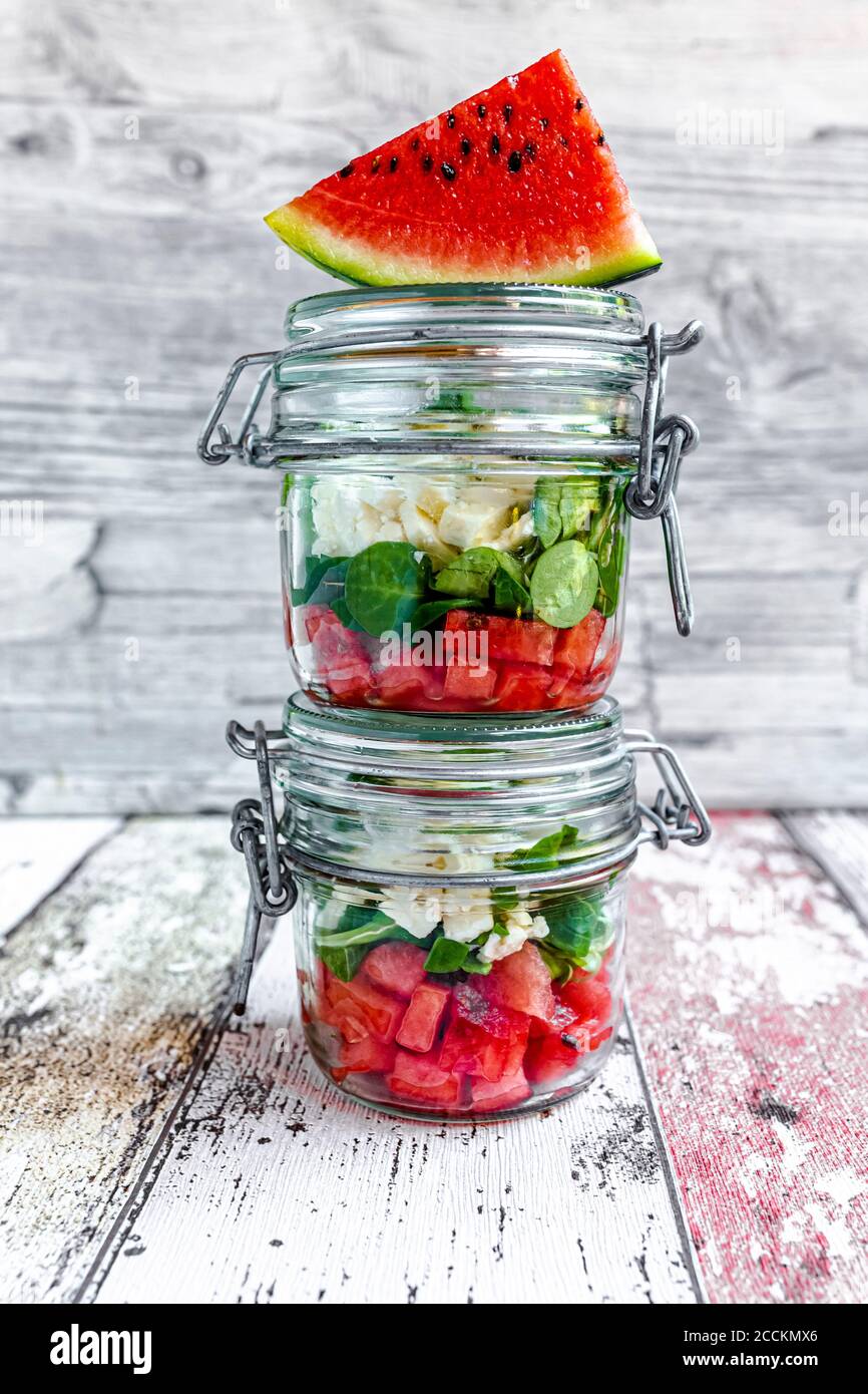 Fetta di cocomero e vasetti di insalata di cocomero con formaggio feta, insalata di mais e menta Foto Stock