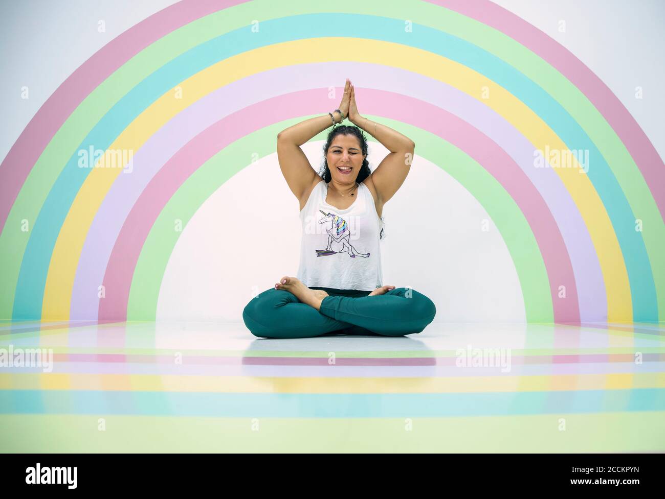 giovane donna in una posa yoga in una stanza colorata Foto Stock