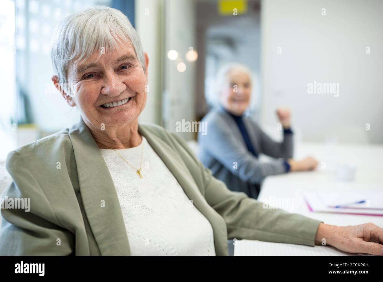 Donna anziana felice che frequenta il corso di formazione degli anziani Foto Stock