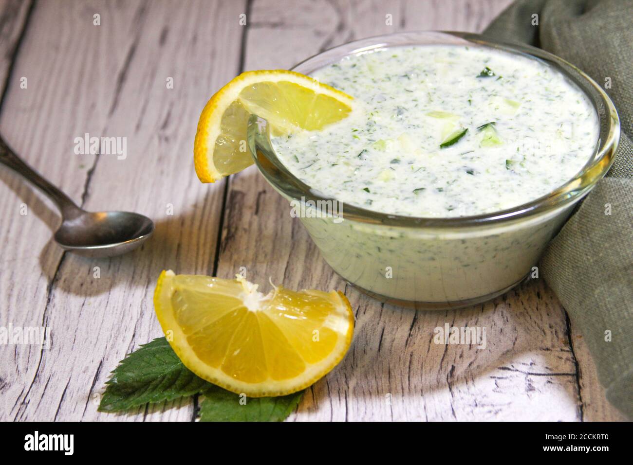 La salsa è composta da kefir, cetriolo verde e limone. Un piatto di cucina iraniana. Snack con patatine. Foto Stock