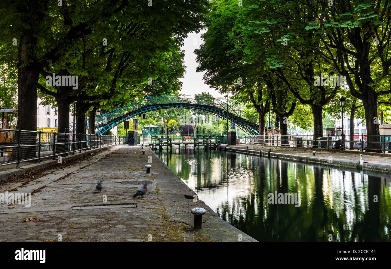 Alberi fiancheggiati da Canal St. Martin a Parigi, Francia Foto Stock