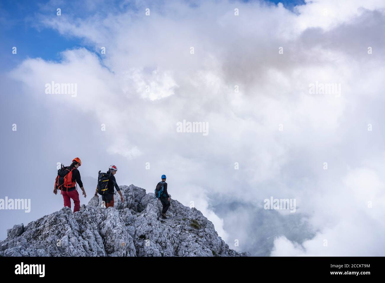 Uomini maturi che camminano in montagna contro il cielo nuvoloso, Alpi Bergamasche, Italia Foto Stock