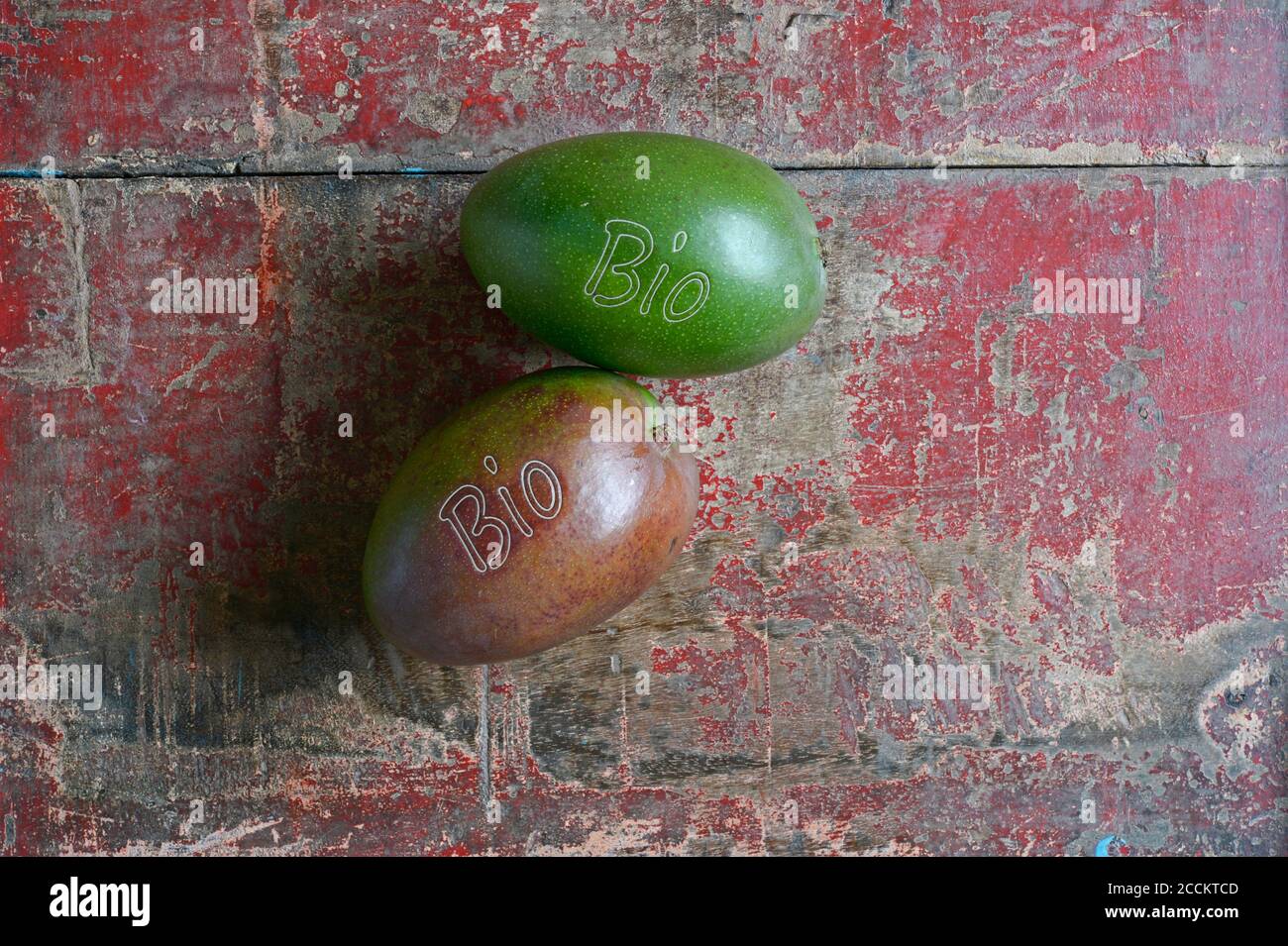 Due frutti di mango e giacente su superficie di legno intemperie Foto Stock