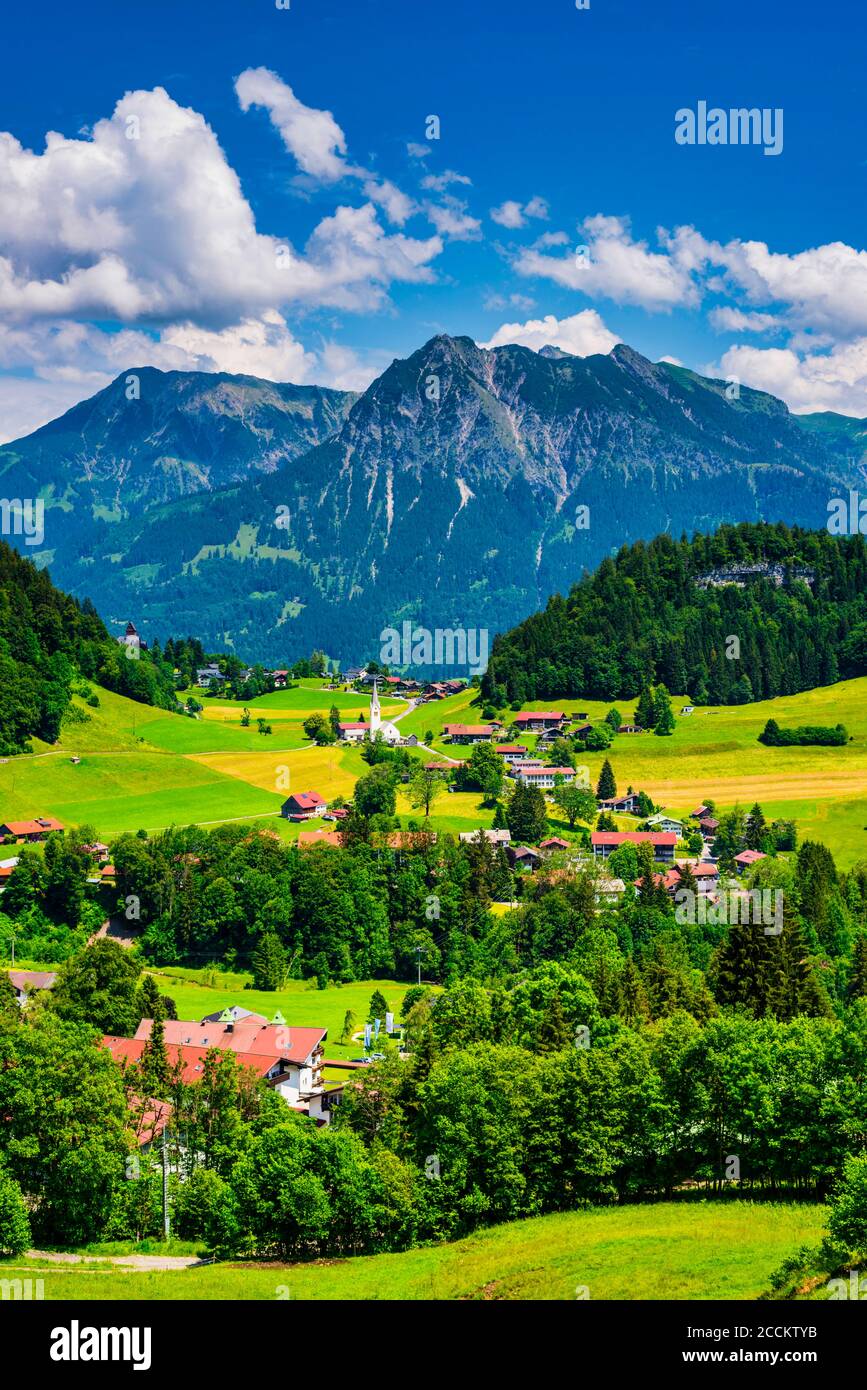 Germania, Baviera, Tiefenbach, villaggio di campagna nelle Alpi di Allgau con Entschenkopf e Rubihorn sullo sfondo Foto Stock