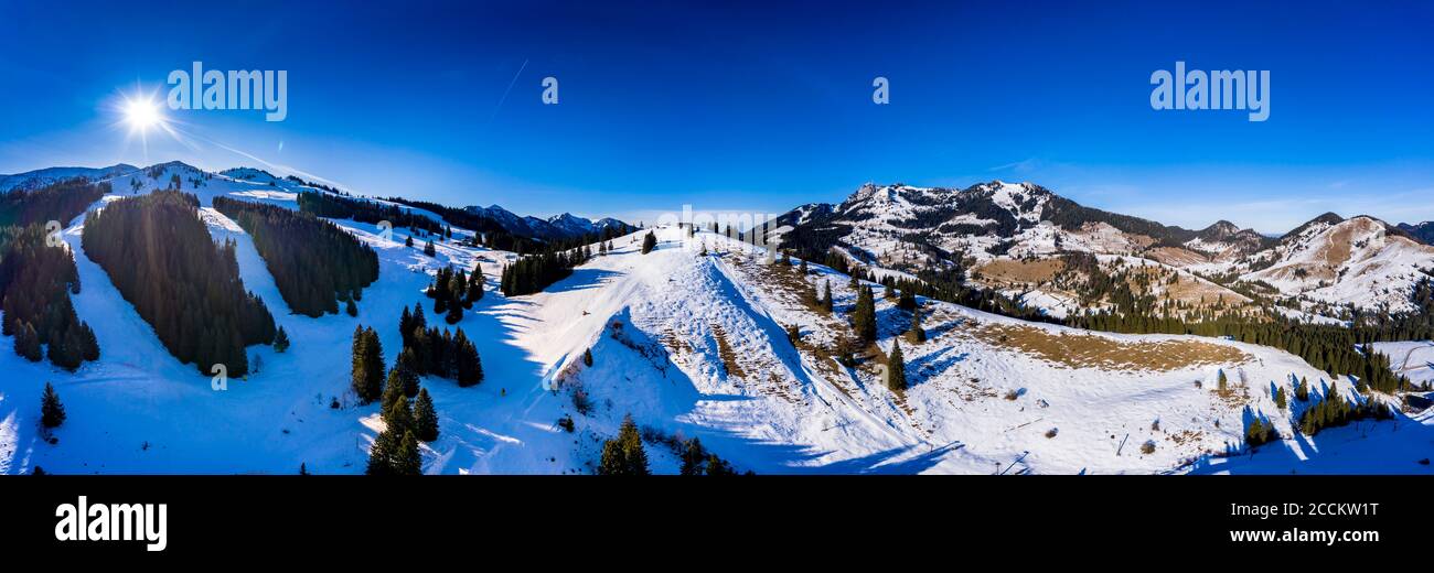 Panorama in elicottero del sole che splende sulle cime innevate di Mangfall Montagne Foto Stock