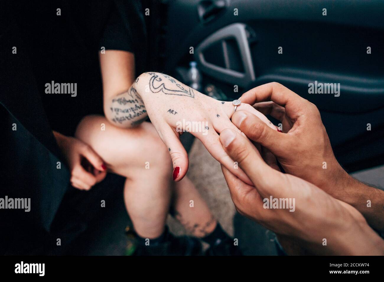 Primo piano del ragazzo che indossa l'anello di fidanzamento alla ragazza Foto Stock