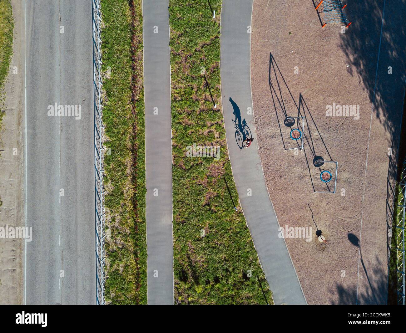 Russia, Tikhvin, uomo in bicicletta sul sentiero vicino parco giochi, vista aerea Foto Stock