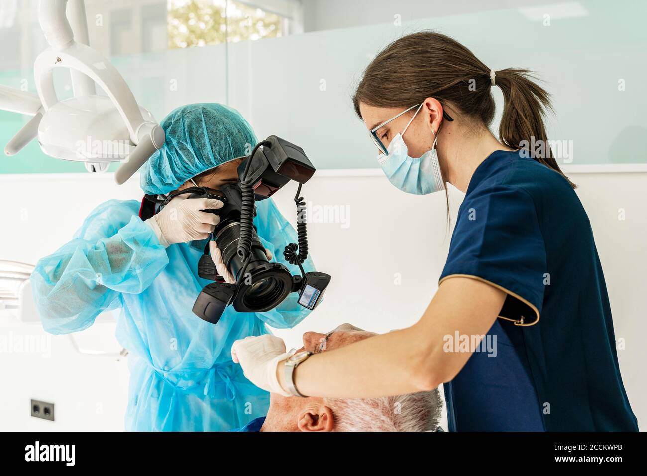 Medico femminile e infermiera con paziente in clinica dentista Foto Stock