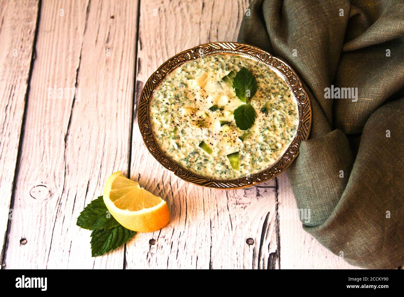 La salsa è composta da kefir, cetriolo verde e limone. Un piatto di cucina iraniana. Snack con patatine. Foto Stock