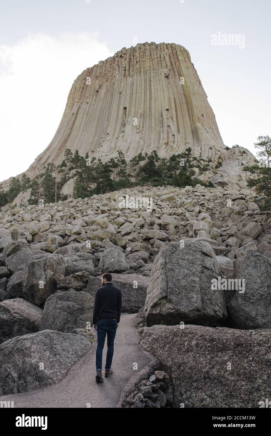 Retro di un maschio in piedi di fronte al Devils Tower National Monument a Devils, Stati Uniti Foto Stock