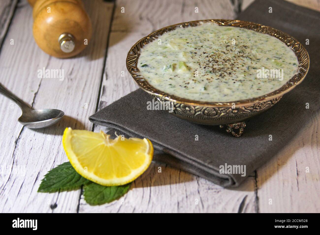 La salsa è composta da kefir, cetriolo verde e limone. Un piatto di cucina iraniana. Snack con patatine. Foto Stock
