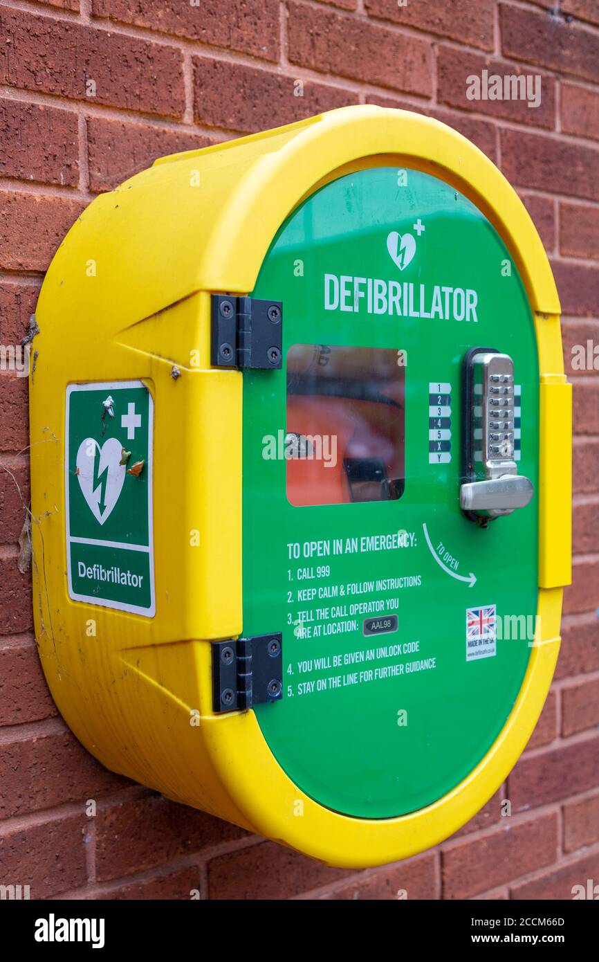 Un defibrillatore o un defibrillatore semiautomatico esterno in una custodia sicura su un muro di mattoni in strada Foto Stock
