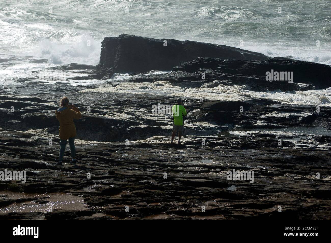 I turisti osservano il mare ruvido intorno al faro di Hook, Co Wexford, Irlanda, Europa Foto Stock