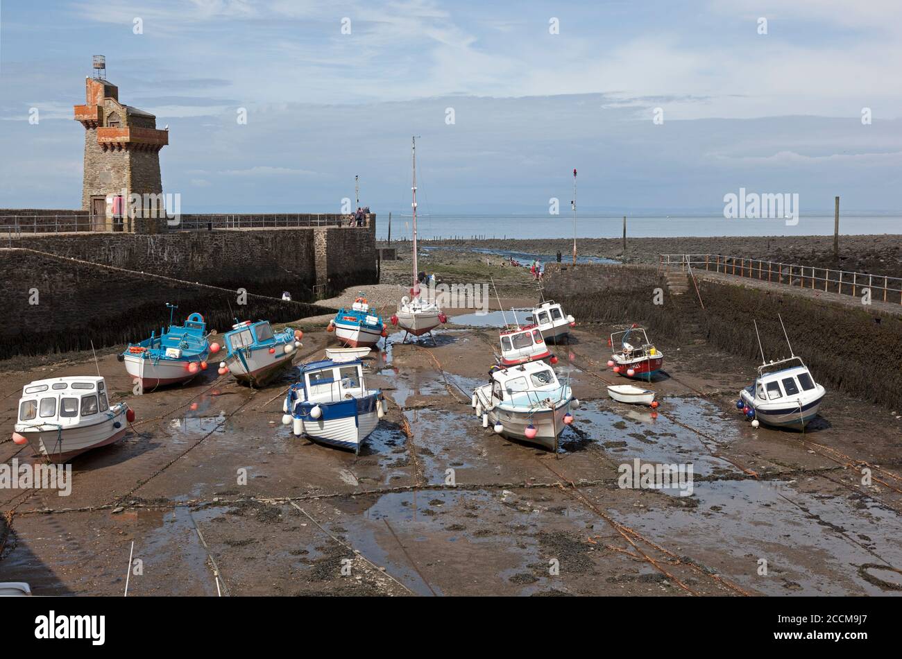 Il pittoresco porto di Lynmouth nel Devon Nord a basso marea con le barche sulla sabbia e i vacanzieri Foto Stock