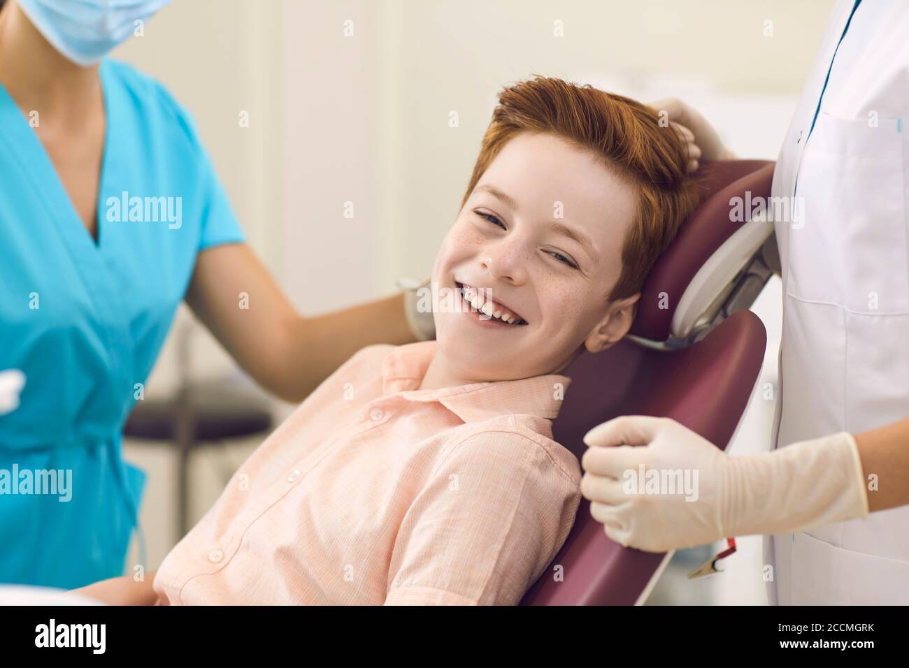 Clinica dentale. Paziente ragazzo positivo guardando la fotocamera e sorridendo durante la visita dentista Foto Stock