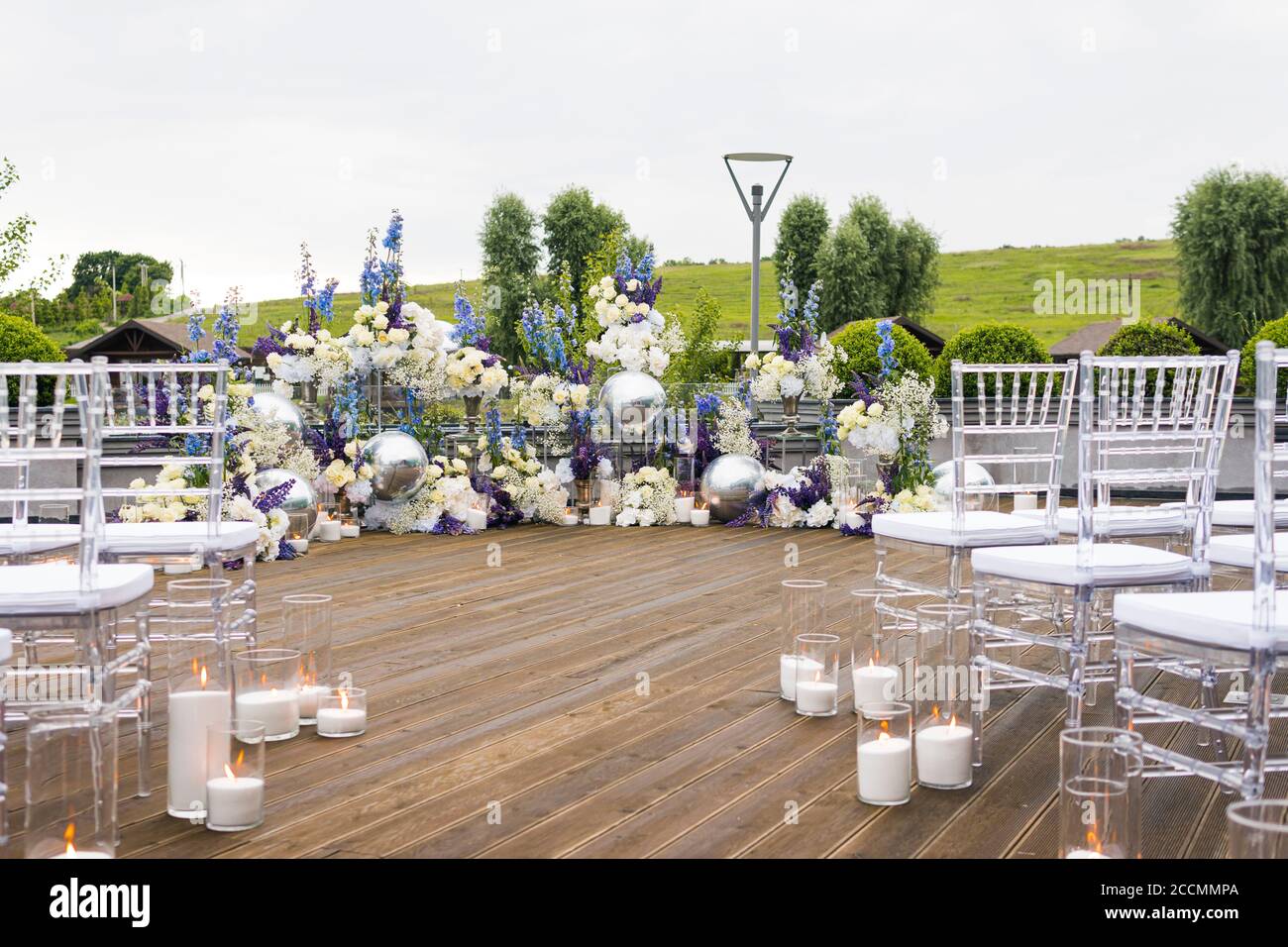 Ricevimento nuziale con fiori bianchi, blu e violetti e candele, all'aperto. Elegante decorazione di nozze di lusso composizione sul posto della cerimonia o foto zo Foto Stock