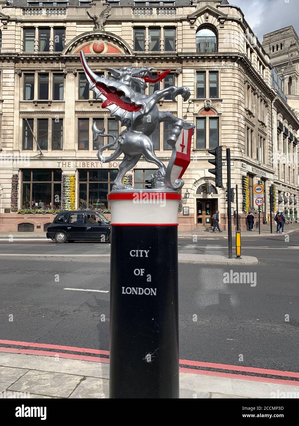 Statua della città di Londra con San Giorgio e il Drago su una base nera a Londra, con un taxi di Londra sullo sfondo Foto Stock