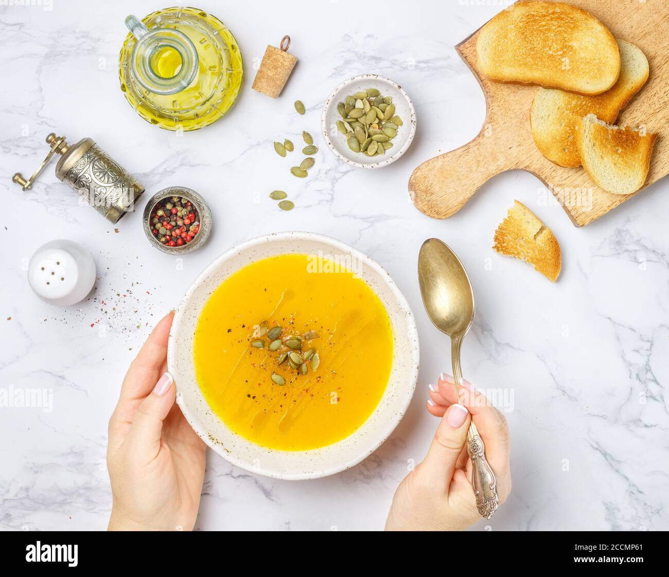 Crema vegetariana dietetica purea di zucca, carote e patate con olio d'oliva, semi e spezie su un tavolo di marmo in un piatto bianco. Messa a fuoco selettiva Foto Stock