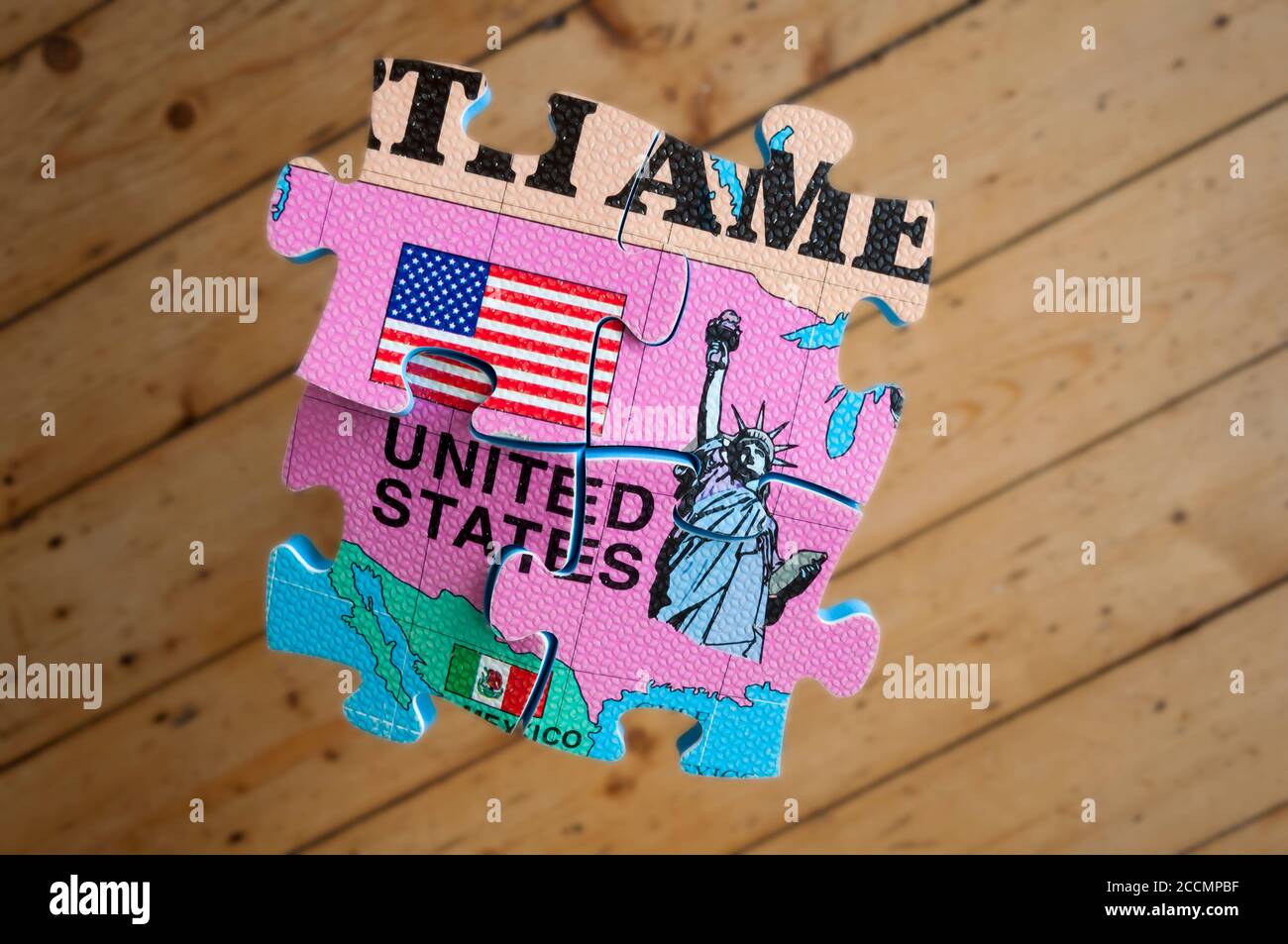 L'America si è isolata e si è spaccata, un'immagine concettuale. Un pezzo di puzzle su un pavimento di legno duro. Foto Stock