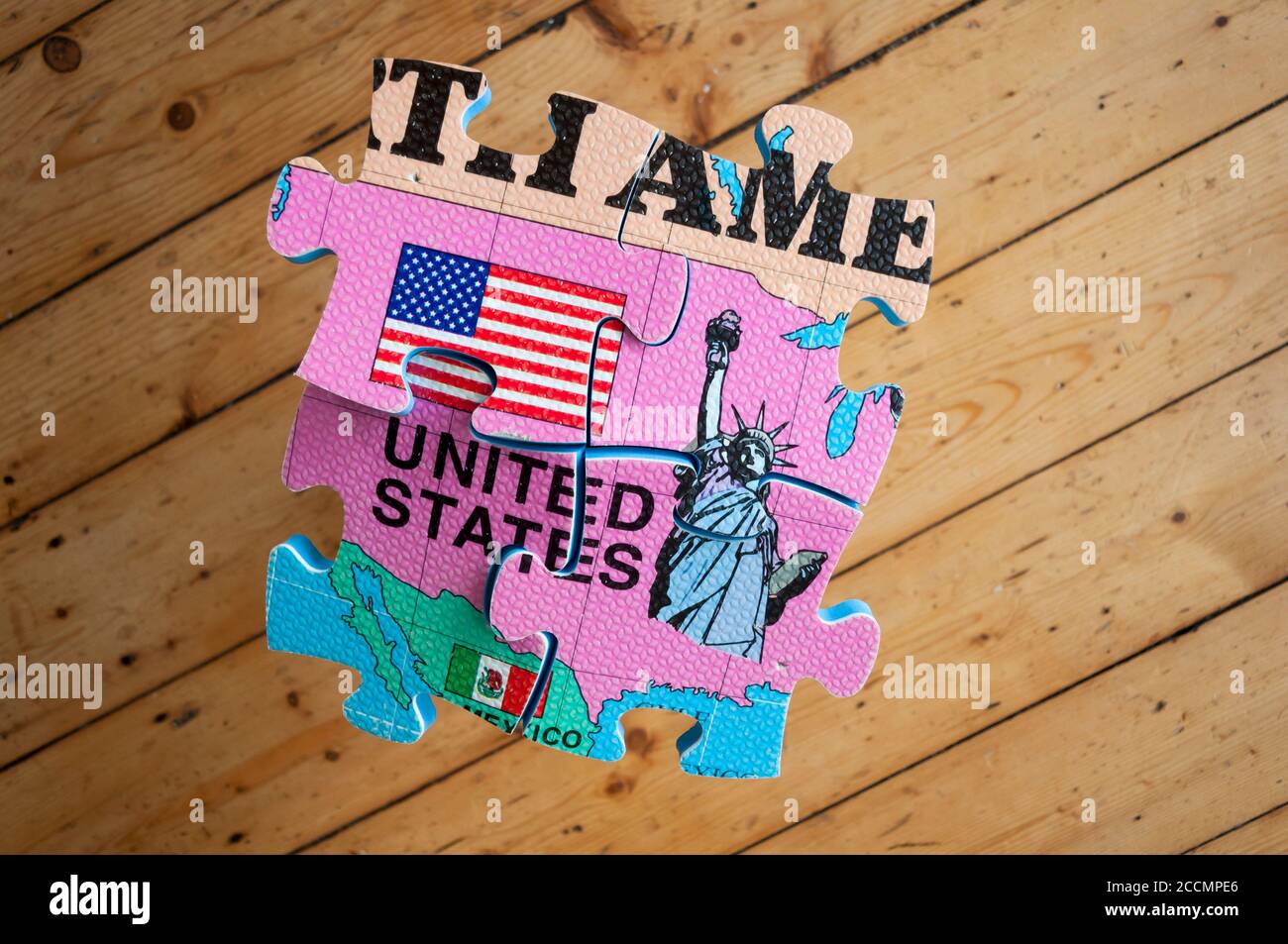 Un'immagine iconica di USA Today con profonde divisioni e polarizzazione. Un pezzo di puzzle 3D scheggiato su un pavimento di legno duro Foto Stock
