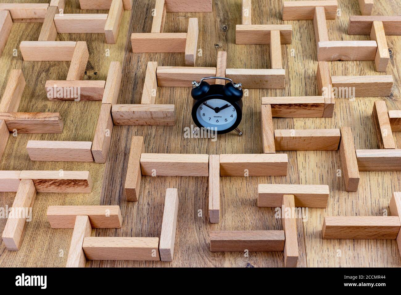concetto di business, modello in labirinto di legno con orologio al centro Foto Stock