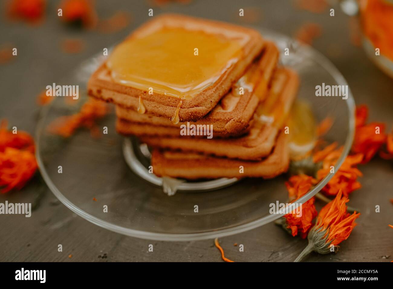 Il miele su prodotti da forno. Tè con fiori di calendula arancione Foto Stock