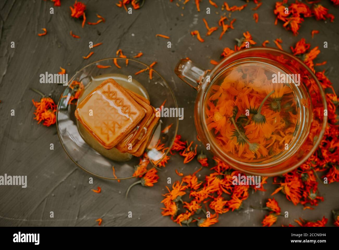 Il miele su prodotti da forno. Tè con fiori di calendula arancione Foto Stock