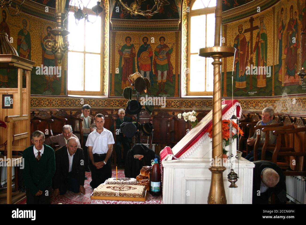 I credenti che pregano in ginocchio all'interno di una chiesa ortodossa Romania Foto Stock