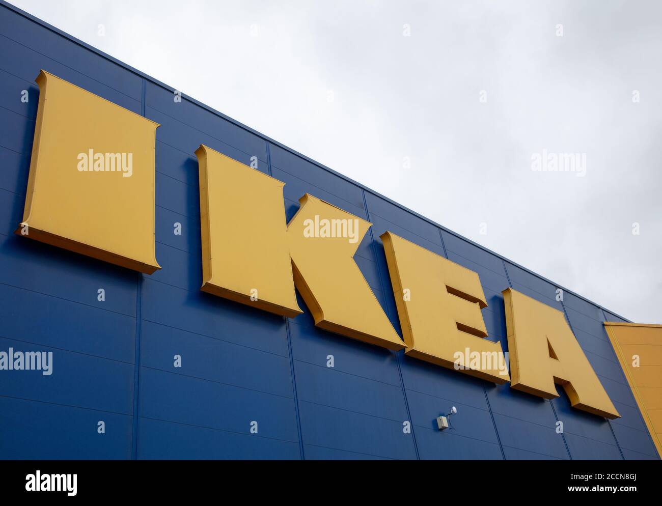 Segno giallo del logo IKEA visto all'esterno dell'edificio di colore blu a Tottenham, Londra contro un cielo grigio. Foto Stock